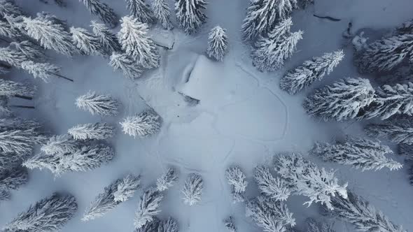 Hunting house in the mountain forest. Winter landscape. Drone aerial view alt