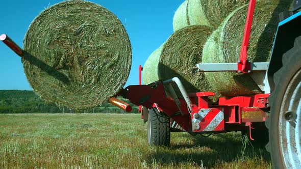 Folding Stacks of Hay in a Truck with Special Equipment. Work in the Field with the Help of Special
