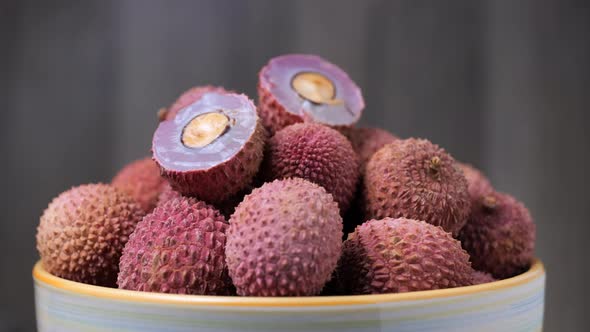 Sweet ripe lychee in a bowl rotating on a table. Close up view.