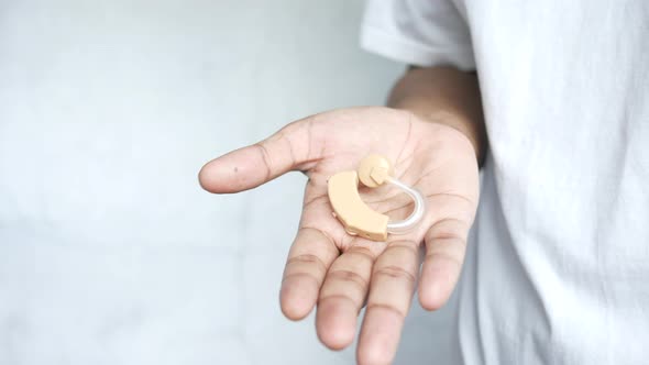 Hearing Aid Concept a Young Man Holding Hearing Aid Equipment alt
