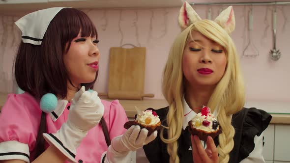 Lovely Asian Female Cosplayers Sharing and Tasting Delicious Cupcakes Indoors alt