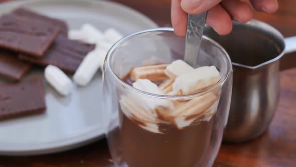 Stir the Marshmallows in a Glass of Milk Cocoa with a Spoon