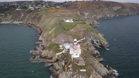 Baily Lighthouse With Bailey Cottage And Town In Background At Howth Head In Howth, Dublin, Ireland. alt