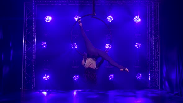 Silhouette Young Girl Performs the Acrobatic Elements in the Air Ring. Shot in a Dark Studio with alt