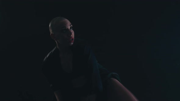 Female Agile Dancer Against a Black Background Dancing and Making a Pirouette alt