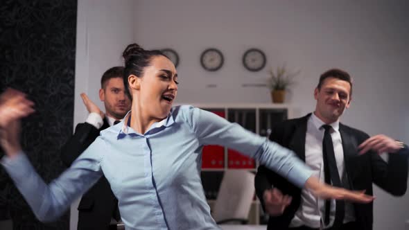 We Happy of Friday Ending Businesspeople Dancing Cheerfully in Office in Front of the Camera. alt