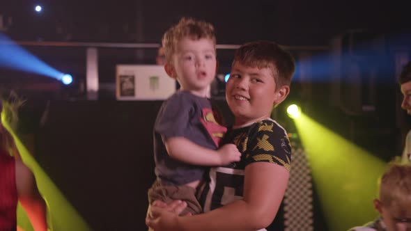 Happy Kids Dancing at a Party with Bright Disco Lights and Music alt