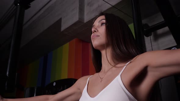 A Sexy Girl Performs an Exercise for Chest Muscles Brings Her Hands Forward alt