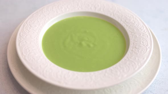 Woman's Hand Adorns Caramel Tuil Mesh Homemade Soup Puree of Green Peas