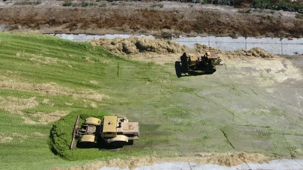 Aerial Shot of Two Bulldozers Moving on a Silo Storage on a Sunny Day in Summer  
