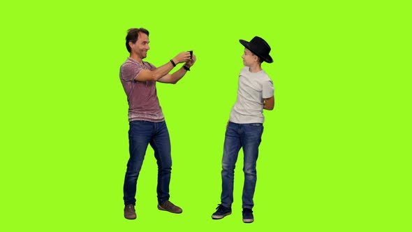 Father with Smartphone Takes a Picture of His Teen Son  alt