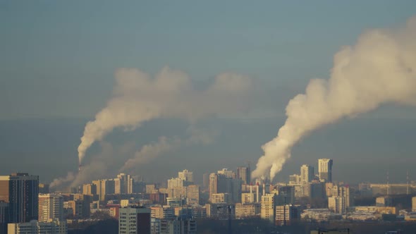 City Pipes Emit Steam Into the Atmosphere Against the City Skyline alt