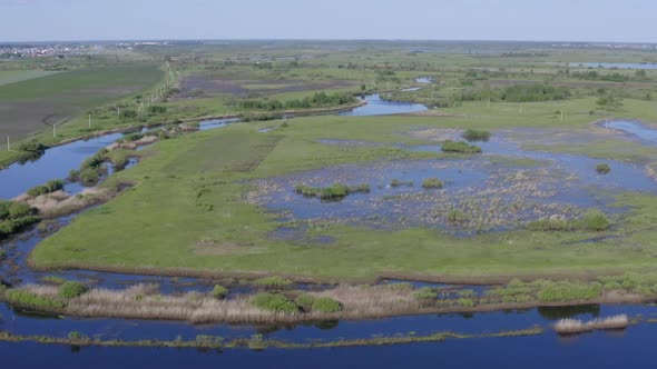 Scenic Aerial View of a River and Green Fields in a Countryside