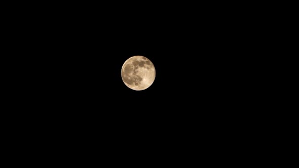 The Full Moon Moves Against the Black Night Sky