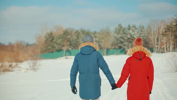 Couple Walking And Enjoying Winter. Freezing Day On Holiday Vacation Trip. Snowy Park. alt