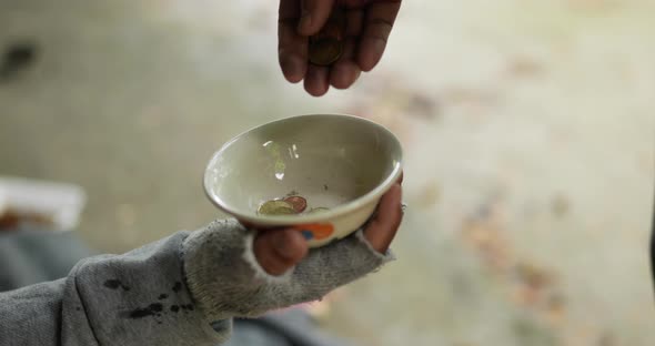 Closeup of Homeless's hand holding old blanket alt