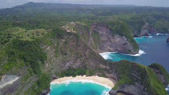 Arial shot flying toward the coast of Kelingking beach in Nusa Penida Indonesia alt