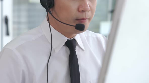 Businessman Wearing Headset Working Actively in Office alt