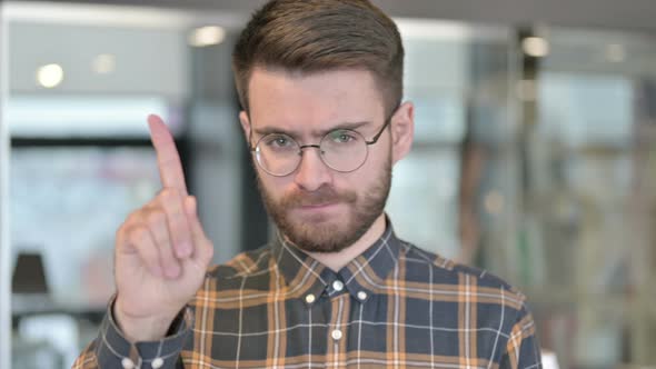 Portrait of Young Designer Saying No with Finger Gesture alt