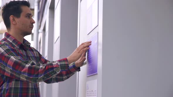 Blind Guy on the Street Reading a Braille Font on a Building Sign alt