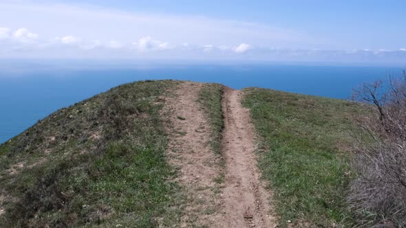 Hiking trail through the hill with the sea in the background