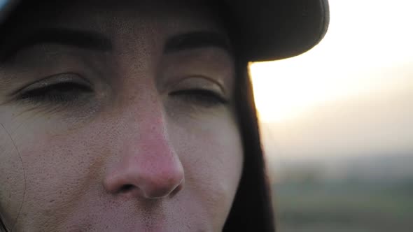 Portrait of Young Woman Looking Up at Sunset Sky alt