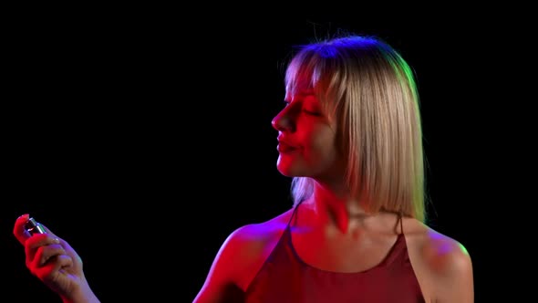 A Young Pretty Blonde Sprinkling Perfume on Herself From a Spray Bottle alt