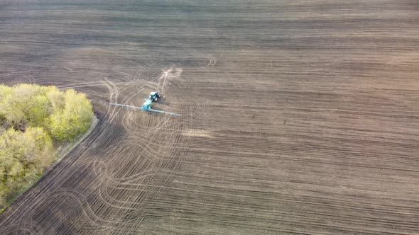 Aerial tractor turning and spraying on land field