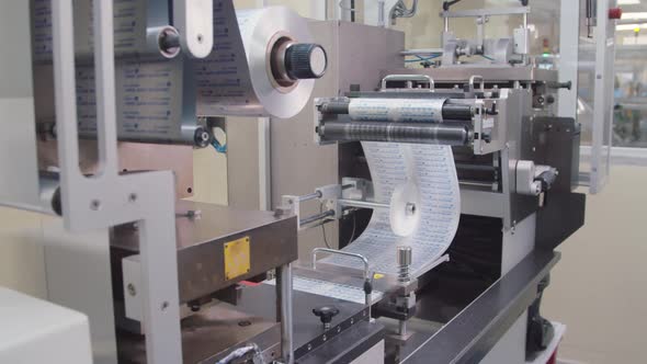Automated Pharmaceutical Machinery is Producing the Foil Pack for Pills at Chemical Factory