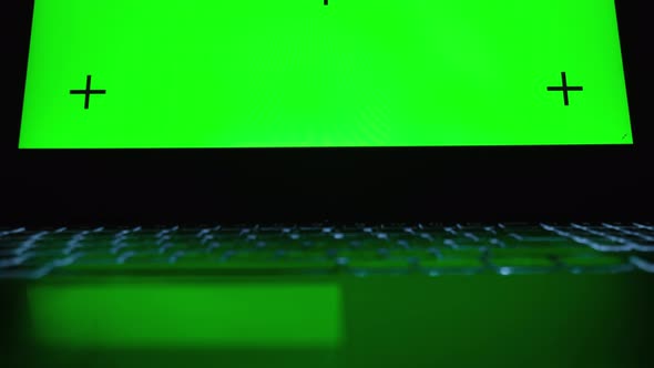 Man at home using laptop computer with green laptop screen