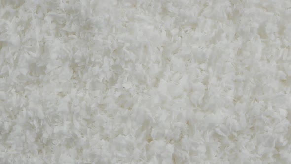 close up of a coconut and grounded coconut flakes alt