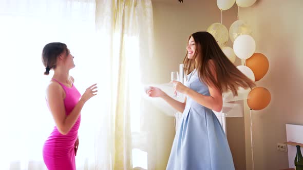 Smiling Bride and Bridesmaid Drinking Champagne. alt
