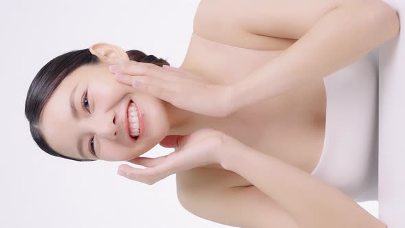 Vertical 4K Video Slow motion Beautiful Asian Girl Touching Her Face. alt