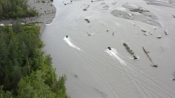 Aerial View of Speedboats Moving Fast on Glacial River in a Wilderness of Alaska USA. Tilt Up Drone alt