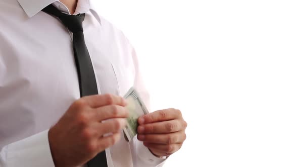 A Man In A White Shirt And Tie Puts Money In His Pocket. Shows Money.