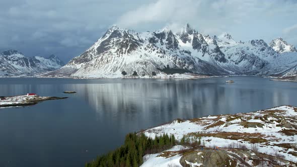 Hyperlapse of the snow capped Austnesfjorden Mountains of Lofoten with clouds streaming over the top alt