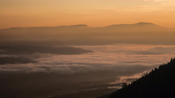 Timelapse of a foggy valley at sunset alt