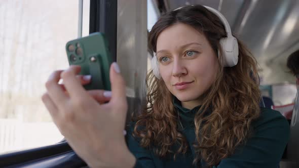Woman Travels By Train Listening to Music in Headphones alt