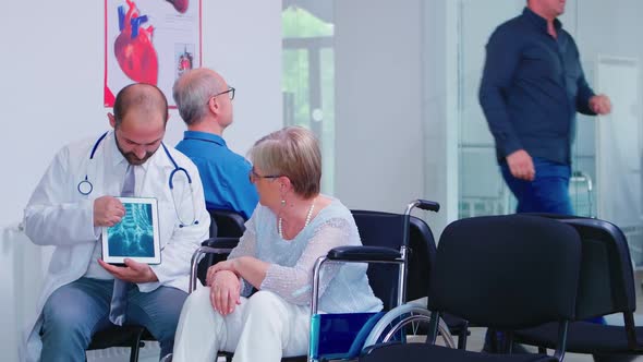 Physician Giving Diagnosis on X Ray Tablet PC alt