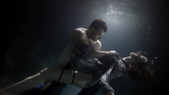 A Man Touches and Passionately Holds His Girlfriend Underwater Lovers Deep Inside on a Dark alt