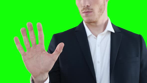 Mid section of a Caucasian man raising hand on green background