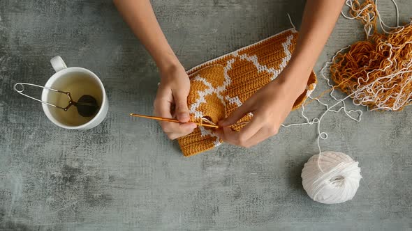 young womans hands crochet hook