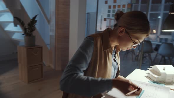Female Architect Drawing Building Plan at Office Desk alt