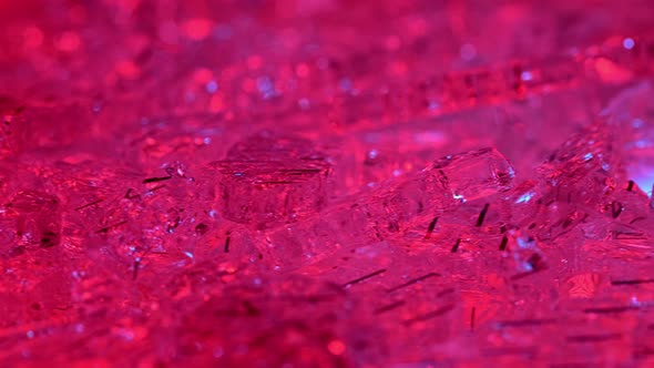 Sparkling, like crystals, shards of broken glass, illuminated with red light. Macro shooting