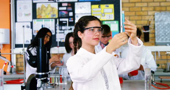 Portrait of schoolgirl doing a chemical experiment in laboratory alt