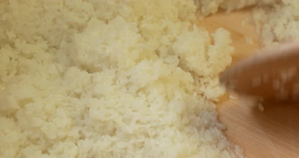 Mixing Japanese White Rice Moistened With Vinegar Mixture Into The Wooden Basin In The Kitchen. - hi alt