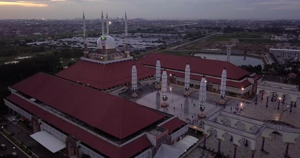 Moving drone shot of the great Mosque of Central Java (MAJT) in suset time. Th sun is orange and the alt