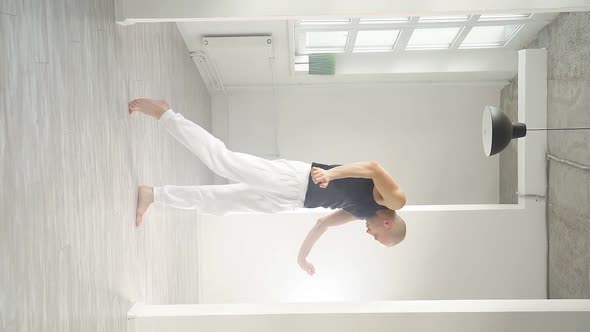 Man Performs Elements of Modern Dance From a White Studio