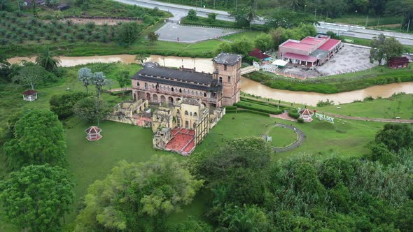 Riverside old Scottish folly, drone fly around the ruined section of Kellie's Castle on green lawn a alt