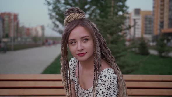 Young Girl with Dreadlocks Posing on a Bench